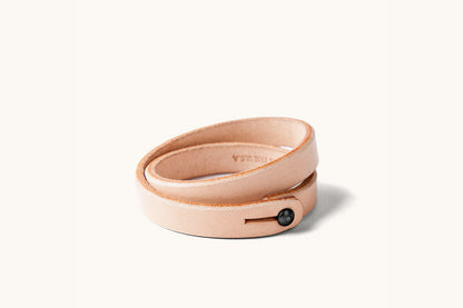 A double wrap natural leather wristband with black closure.