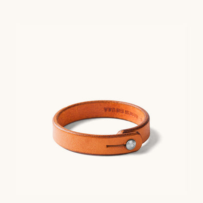 Tan leather wristband with metal rivet closure.